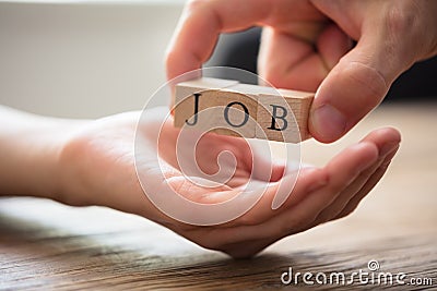 Businessperson Giving Wooden Block With Job Text To Candidate Stock Photo