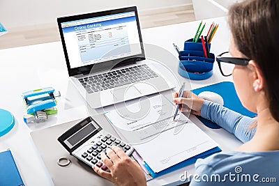 Businesswoman Calculating Invoice Using Calculator Stock Photo