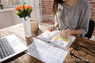 Businesswoman Making Schedule On Personal Organizer Stock Photo
