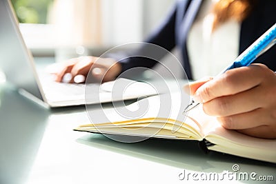 Close-up Of A Businesswoman`s Hand Writing Note In Diary Stock Photo