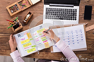 Businesswoman Writing Schedule In Calendar Diary Stock Photo