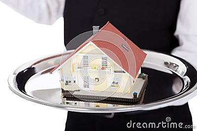 Close-up of a butler with model of a house Stock Photo