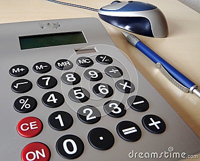 Part of the desk with calculator, ballpoint pen and pc mouse Stock Photo