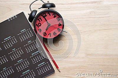 Close up of calendar, alarm clock and pencil on the table Stock Photo