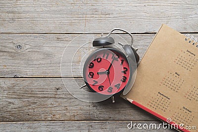 Close up of calendar, alarm clock and pencil on the table Stock Photo