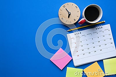Close up of calendar, coffee, clock and pencil on the blue table Stock Photo