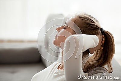 Calm young female relax on couch at home Stock Photo