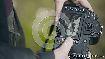 Close-up of camera screen with wedding photos. Action. Professional camera in hands of photographer looking at resulting Stock Photo