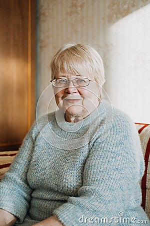 Close up candid, authentic portrait of senior plus size blonde woman at home. Portrait of mature woman with eyeglasses Stock Photo