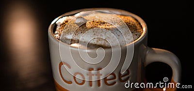 Close up of cappuccino with cinnamon and milk foam in cup on dark table Stock Photo