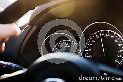 Close-up car speedometer, with an arrow frozen at speed of 120 km / h. Details and black dashboard of car interior. Stock Photo