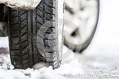 Close-up of car wheel in winter tire on snowy road Stock Photo