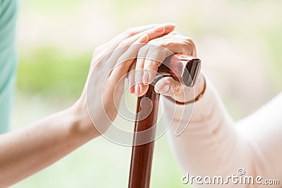 Close-up of caregiver holding hand of a senior person with walki Stock Photo