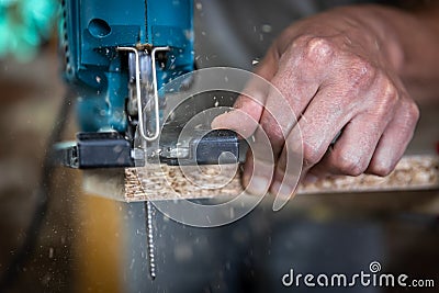 Close-up process of cutting wood board with jigsaw Stock Photo