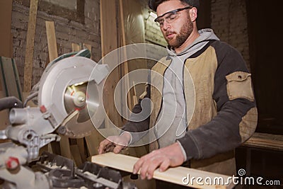 Close-up of a carpenter doing woodwork. a small business owner was cutting a wooden Board with a circular saw in a workshop Stock Photo