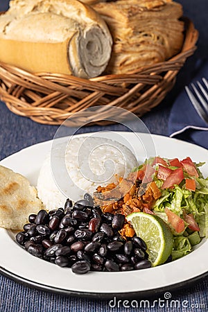 Close up of Casado, typical Costa Rican dish with rice and beans on blue tablecloth Stock Photo
