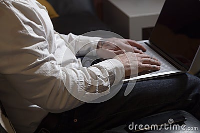 Close up of casual businessman working through a laptop at the table on sofa at home, student studying an online course, E- Stock Photo