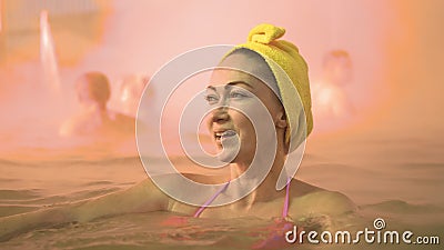 Close up caucasian woman in a swim in hot saline mineral water bath at a traditional spa outdoor with soft magic pink Stock Photo