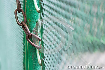 Close up chain locked on green fence gate Stock Photo