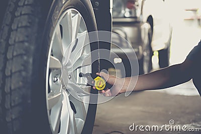 Close-up checking car tyre pressure with gauge Stock Photo