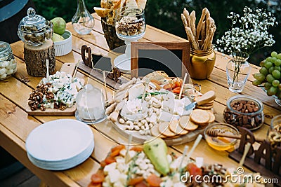 Close-up cheese bar of several kinds of cheese, snacks, honey, nuts decorated on wooden table at the wedding party Stock Photo