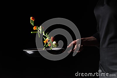 Close-up, chef preparing vegetables in a skillet frying them. Hotel business and the menu in restaurants, the book of recipes. On Stock Photo