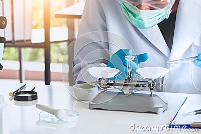 Close up, chemist or scientist researcher using mechanical scale for gathering and measuring specimen in experiment at laboratory Editorial Stock Photo