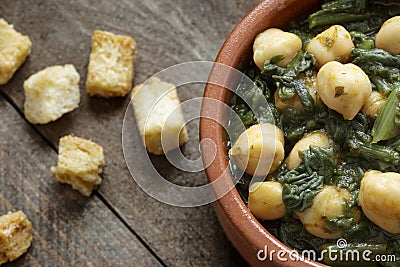 Close up of Chickpea and spinach stew on rustic wooden background. Spanish tapas Stock Photo