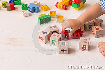 Close up of child`s hands playing with colorful plastic bricks and red motocicle at the table. Toddler having fun Stock Photo