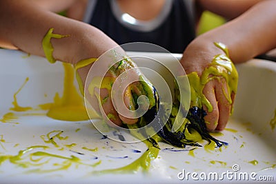 CLOSE UP OF CHILD`S HANDS PLAYING WITH HANDMADE GALACTIC SLIME Stock Photo