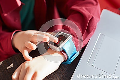 A close-up of child`s hands with smart watch. Touching electronic watch. Wearable gadget concept. Showing time. Using smartwatch w Stock Photo