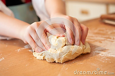 Close up of a childs hands kneeding dough on a wooden surface Stock Photo
