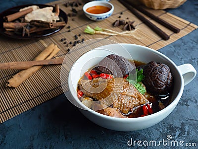 Close-up of Chinese chicken soup in a white cup decorated with Chinese shiitake mushrooms, goji berries, chicken blood and Stock Photo