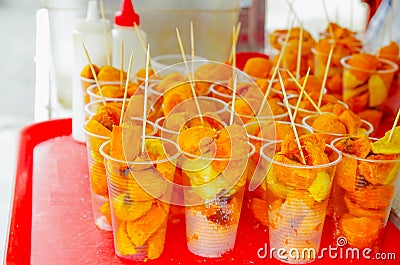 Close up chontaduro delicious amazonian tropical fruit Bactris gasipaes, inside of plastic glasses, over a red plastic Stock Photo