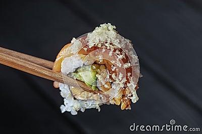 close up of chopsticks taking portion of sushi roll on the table restaurant eating sushi roll using chopsticks. Stock Photo