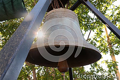 Close-up of church bell in the rays of the setting sun Stock Photo