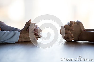 Close up clasped female hands of two businesswomen negotiate at table Stock Photo