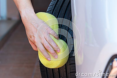 Cleaning car wheel, wiping tire after cleaning on car washing Stock Photo