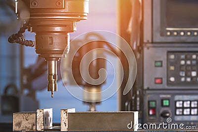 CNC milling machine tool with mill in chuck preparing to process metal detail in workshop area Stock Photo