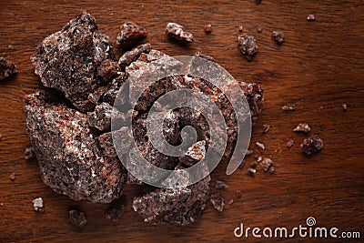 Close-up of coarse Himalayan Black Salt sodium chloride edible on wooden top background. Stock Photo