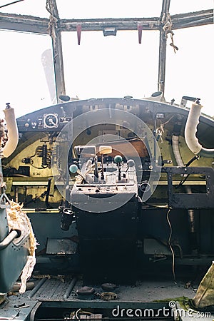 A close up of the cockpit of a vintage airplane. The steering wheel, dashboard, seat and climb levers are visible. Decommissioned Stock Photo