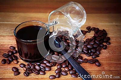 Close up of coffee bean and shot of black coffee on wood table Stock Photo