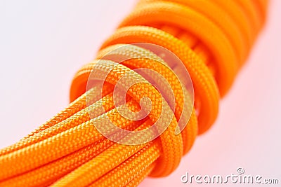 Close-up on a coil of orange paracord on white background Stock Photo