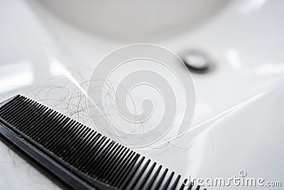 A close-up comb with hairs. Treatment for alopecia in men, hair loss. Hair transplantation Stock Photo