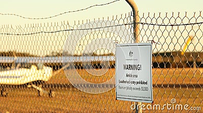 Warning sign at regional airport. Security fence and infrastructure at airfield Editorial Stock Photo