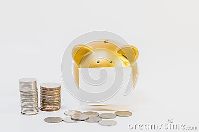 Conceptual image, pile of coins close gold piggy bank on white background. Stock Photo