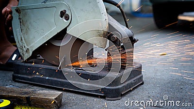 Close up a construction worker cuts off metal fittings with a grinder. Stock Photo