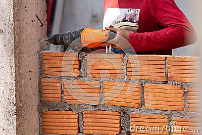 Close-up Construction workers are using pillar punching machines to insert rebar to line the bricks to create a stable wall Stock Photo
