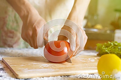 Close up cook hands with knife cut tomato on the wooden board cooking dish f Stock Photo