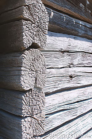 Close-up of the corner of an old strong shed. Corner of a wooden peasant house. Untreated natural wood with cracks in the round se Stock Photo